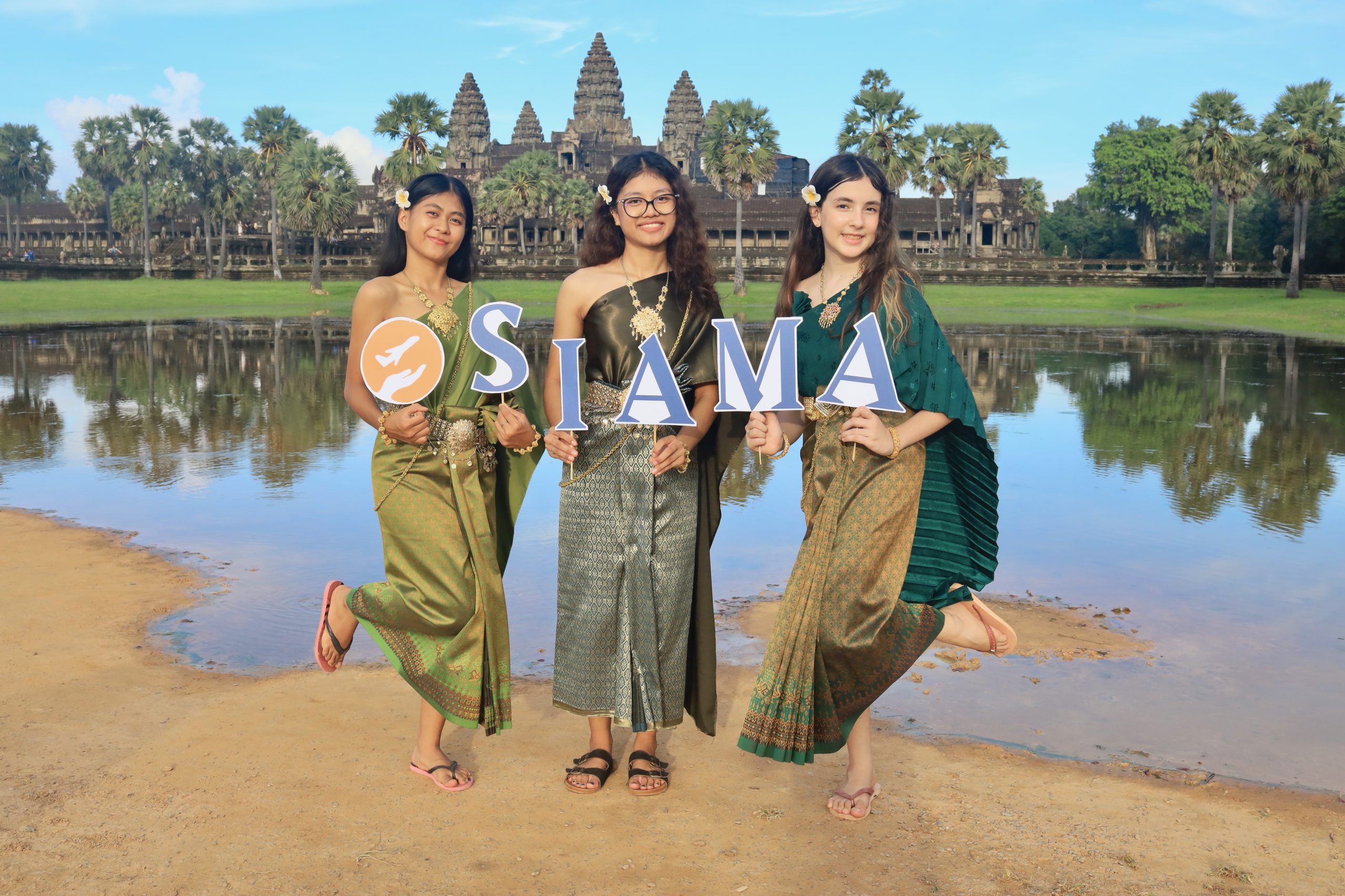 3 girls in front of a pool, with Angkor Wat in the background
