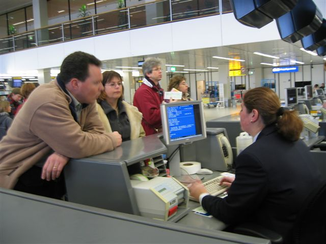 passengers at an airport check in counter