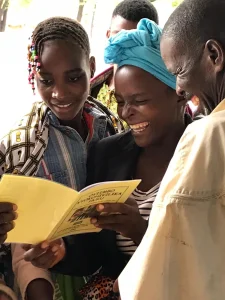 A local church congregation in Angola receiving a small hymnal printed in their native Olungambwe language.